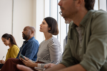 Woman using her phone to take notes during a presentation