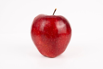 Single red apple shows glossy texture from an overhead perspective on clean white studio.