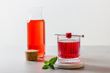 Raspberry cocktail in a glass on a marble stand