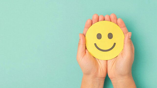 Spread positivity and share happiness by holding a cheerful yellow smiley face in your hands, perfect for expressing joy and optimism