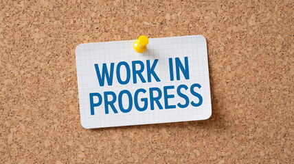 Clear message on cork board announcing ongoing project status, ideal for office or creative spaces