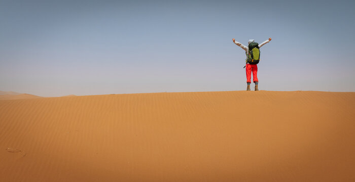 Backpacking woman hiking  in the desert - Powered by Adobe