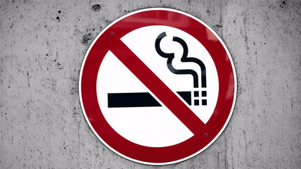 Clear no smoking sign prominently displayed on a textured concrete wall, enforcing health regulations and promoting clean environments.