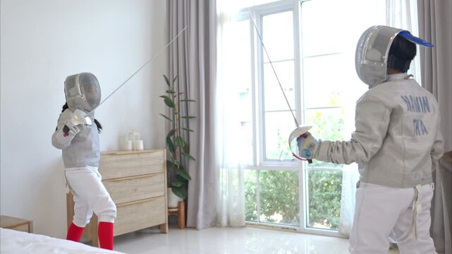 Before the tournament day, a boy and girl dressed in fencing gear are rehearsing in gym