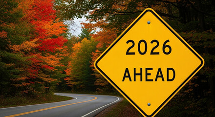 2026 Ahead Road Sign with Autumn Foliage - Stock Photo