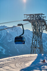 Gondola, cable car and ski lift with mountain, tree, blue sky on a sunny day at resort Krasnaya Polyana.