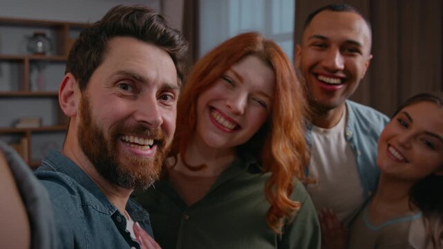 Webcam web camera view Caucasian man inviting friends making selfie together smiling posing four multiethnic people buddies men women group photo looking at smartphone laughing funny record video