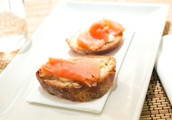 delicious canapes of salted, smoked salmon fillet on slice of fresh ciabatta bread
