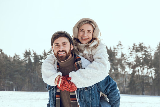 Happy couple spending time together and having fun in a winter forest
