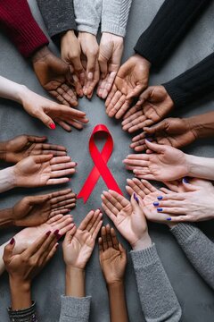 Hands unite to form a red ribbon symbolizing diversity and inclusion in healthcare for all