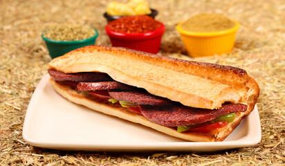 a delicious sandwich with sausage, vegetables, peppers and spices,close up