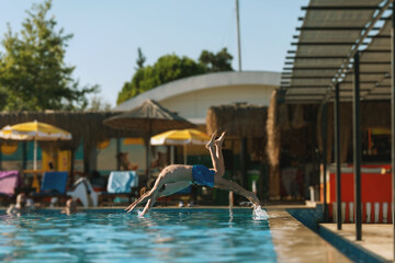 Two men diving to the swimming pool,