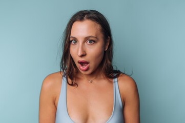 Woman with surprised expression against blue background