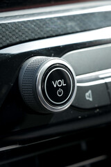 Obraz premium Sound volume tune button in car with black interior. Vertical portrait photo. 