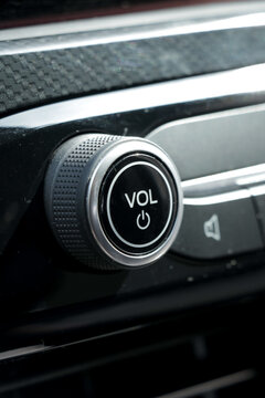Sound volume tune button in car with black interior. Vertical portrait photo. 