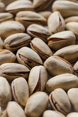 Pistachios ready to peal on a white background with shallow depth of field. Pistachio nuts, healthy, natural snack treat.