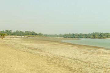 Golden hour light serene tidal flat, with wet sand on sea beach