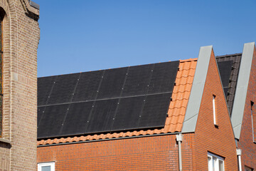 Solar panels on roof. Renewable energy solutions building house in neighborhood. Green energy, clean energy, sustainability, eco-friendly technology powered by the sun. 