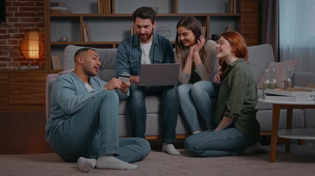 Multiracial four friends ethnicity diversity clients ordering food with laptop credit bank card online service smiling people using e-commerce websites buying at home party in living room men women