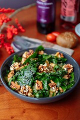 A colorful spinach salad topped with nuts, seeds, and fresh ingredients, perfect for healthy eating and enjoyment