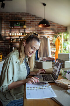 Woman working on laptop in cozy workspace