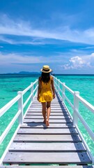 Woman walking on a wooden pier to the turquoise sea