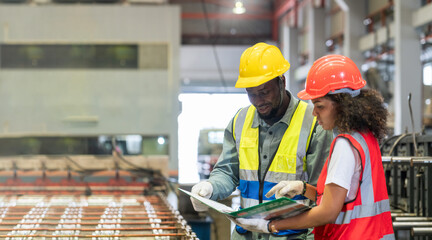 Man and woman is focused working on a machine in a factory. Staff and engineer is inspecting the operation of machinery in a factory.