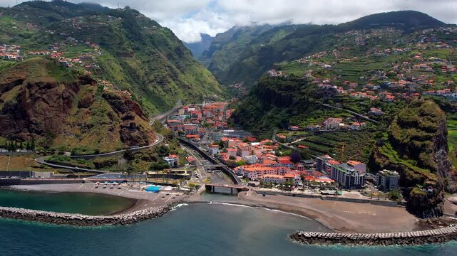 Ribeira Brava Madeira Drone 4K: Coastal Town and Black Sand Beach, Dramatic High Mountains Backdrop, Atlantic Island Landscape, Scenic Portugal Travel Destination, Cinematic Aerial View 