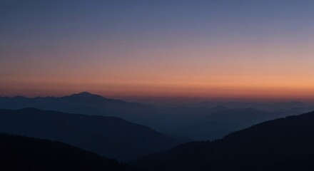 Fototapeta premium Silhouetted mountain ranges at sunrise or sunset