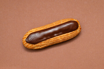 Chocolate éclair on brown background