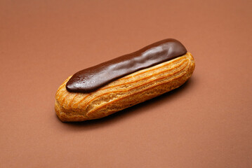 Chocolate éclair on brown background