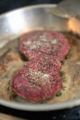 Frying pan with beef steak being cooked at home vertical shot