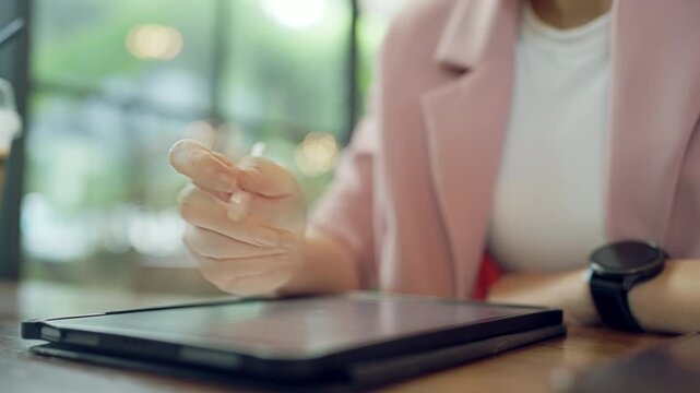 Creative close-up of female hand using digital stylus pen on screen for drawing or sketching on tablet