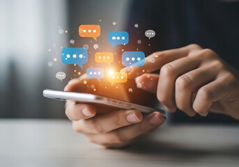 Close up of person using smartphone with speech bubble icons floating above the screen, representing communication and social media engagement