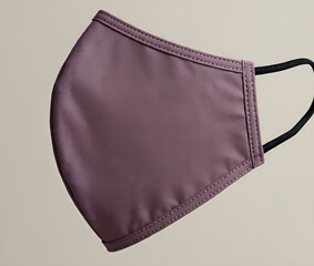 Close up of a reusable purple face mask with black elastic straps