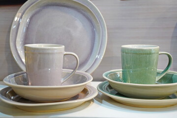 Various ceramic mugs are displayed on the table.