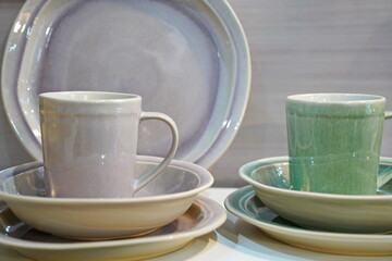 Various ceramic mugs are displayed on the table.