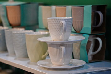 Various ceramic mugs are displayed on the table.