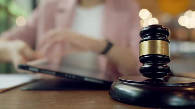 Scene showing the blend of traditional law symbolized by gavel with digital note-taking on tablet