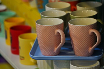 Various ceramic mugs are displayed on the table.