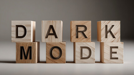Wooden blocks on a surface arranged to spell "DARK MODE" in a clear, bold typeface, suggesting a theme or setting option.