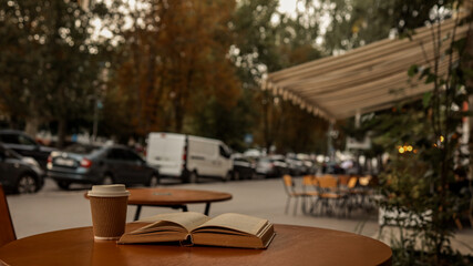 Coffee and a book on a table at an outdoor cafe