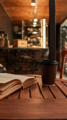 Coffee cup and book on a wooden table in a cafe