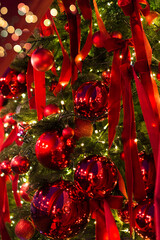 Merry christmas card. Winter holiday theme. Happy New Year. Christmas tree branches with red decorations, balls, garlands, bokeh. Postcard