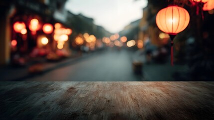 Obraz premium A warm blurred street scene at night illuminated by hanging lanterns with a wooden surface in the foreground