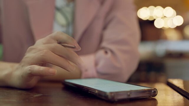 Blurred female face with sharp focus on hands holding smartphone, concept of attention and digital behavior