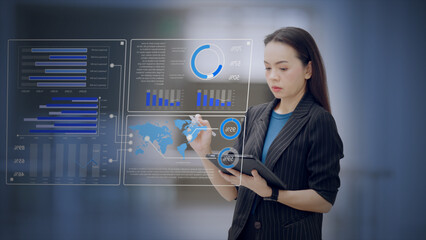 Executive woman working with a virtual analytics dashboard interface, interpreting charts and business data to guide strategic decisions in a corporate environment.