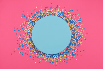 Round blue frame on pink background with colorful confetti border