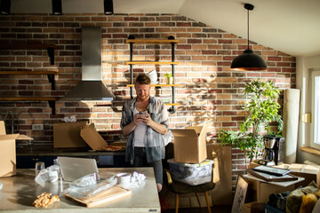 Man in a modern kitchen with moving boxes