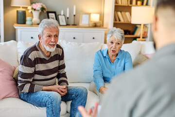 Mature couple consultation session with health therapiest or doctor at home or in doctor's office, or an insurance real estate agent